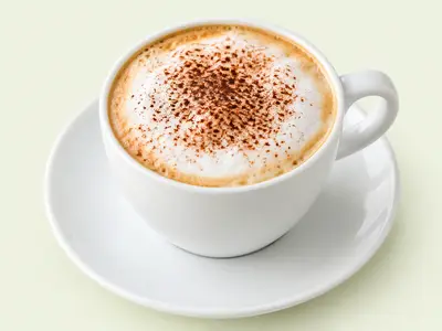 Tasse de cappuccino à la mousse de lait saupoudrée de cacao