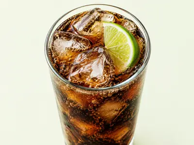 Verre de soda au cola avec glaçons et une rondelle de citron vert, illustration du Coca-Cola Zero