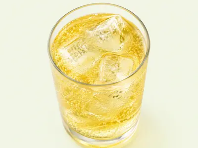 Verre de boisson énergisante jaune pétillante avec glaçons, illustration du Red Bull