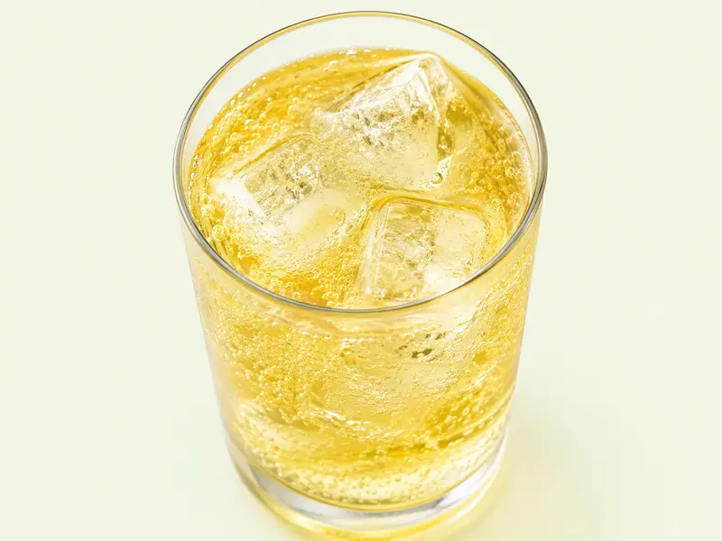 Verre de boisson énergisante jaune pétillante avec glaçons, illustration du Red Bull