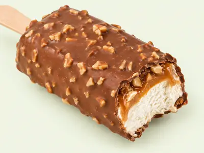 Barre glacée enrobée de chocolat et d'éclats de cacahuètes, croquée sur le côté, illustration du Snickers glacé